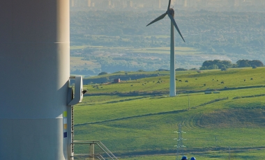 Wind turbine with cityscape in background